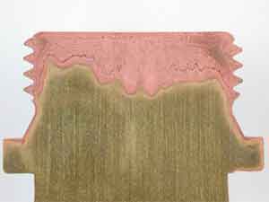 Dezincification of brass component leaving porous copper rich region (pink)